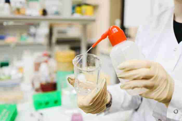 person cleaning beaker 3735735 e1618392591874